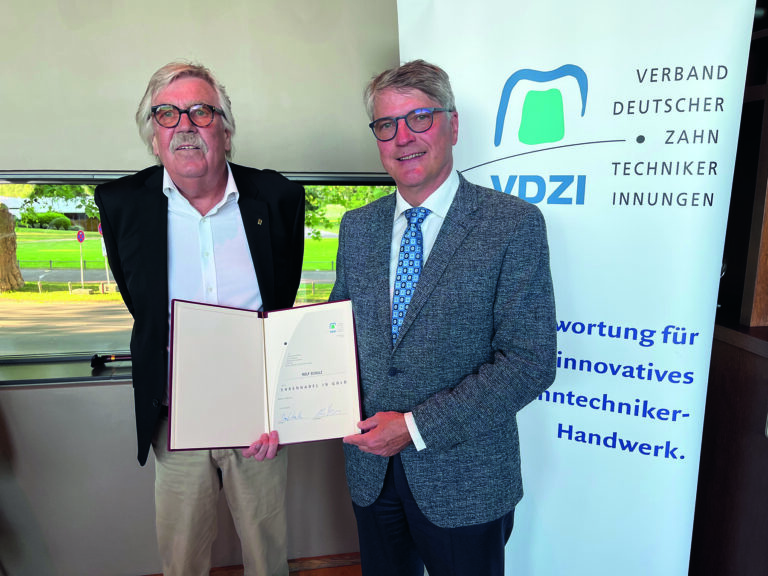 VDZI-Präsident Dominik Kruchen (r.) übergibt die Urkunde der Goldenen Ehrennadel an Ztm. Rolf Schulz.